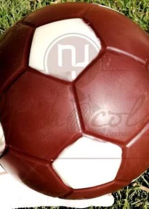 Red-brown soccer ball on green grass, with white patches visible on the panels.